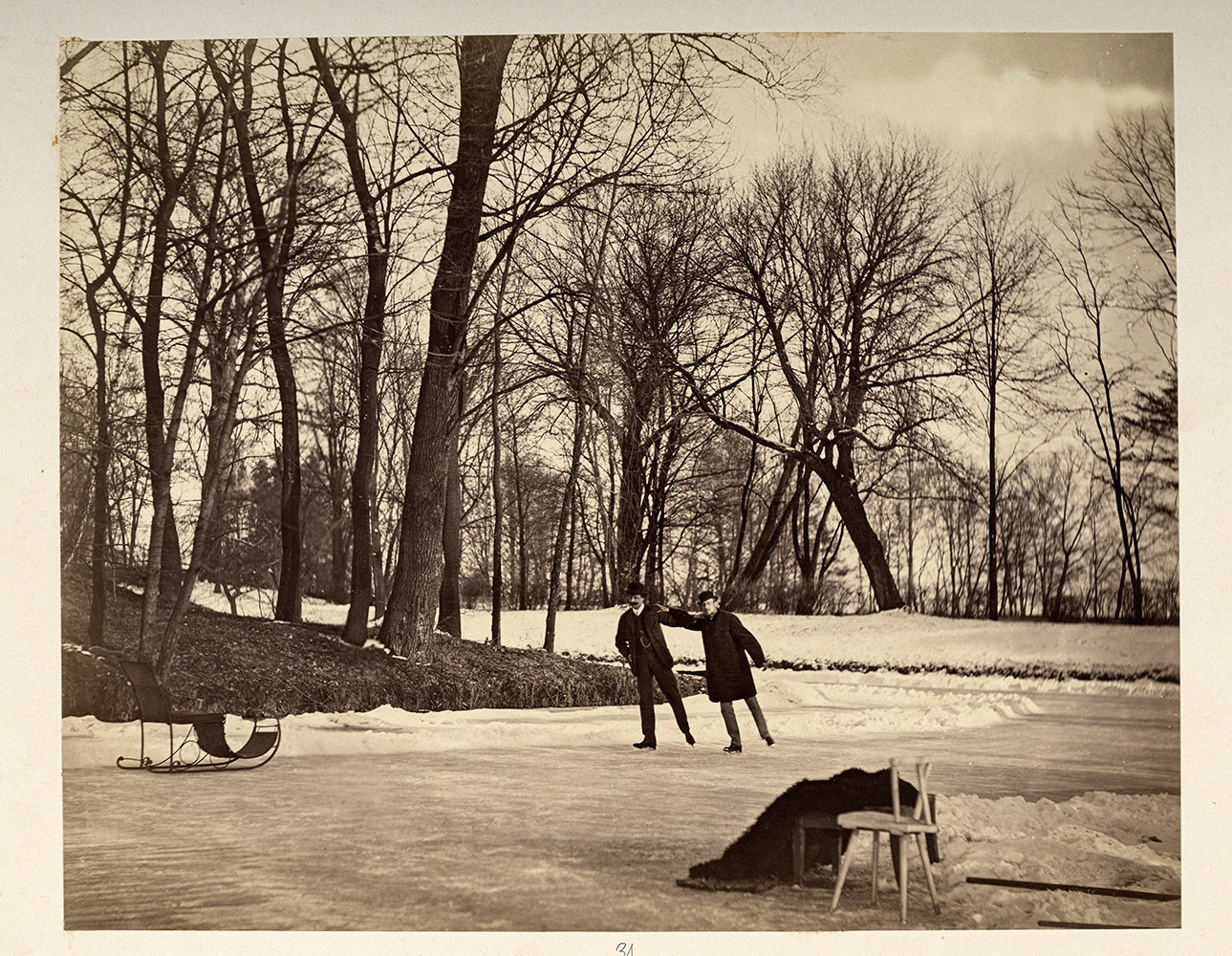 Jan Zamoyski i Andrzej Zamoyski (syn Pana Andrzeja) na ślizgawce w Krakowie, pocz. l.70. XIX w. Pozioma, czarno-biała fotografia przedstawiająca Jan Zamoyskiego i Andrzeja Zamoyskiego (syna Pana Andrzeja) na ślizgawce w Krakowie, pocz. l.70. XIX w., fot. Walery Rzewuski. Na pierwszym planie nieco z prawej strony fotografii, na zamarzniętym stawie, dwaj mężczyźni w średnim wieku. Jan Zamoyski, pierwszy z lewej, ubrany w zimowy płaszcz i melonik, obok również w meloniku Andrzej Zamoyski, ubrany w jednolity ciemny garnitur z kamizelką. Mężczyźni są w ruchu, lekko pochyleni w prawą stronę, chwytają się za barki. Na nogach maja łyżwy. W tle niewielka skarpa porośnięta drzewami.
