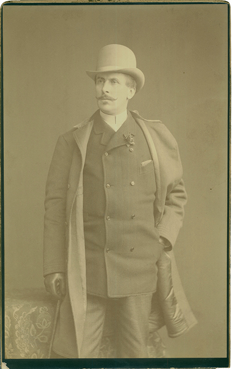 Konstanty Zamoyski, fot. Reichardt & Lindner, Berlin, ok. 1885 r.; Materiał/technika: papier fotograficzny; wymiary: 29 x 18,2 centymetrów. Fotografia zabytkowa, pionowa. Mężczyzna w średnim wieku, w ujęciu en face do kolan, głowa i wzrok skierowany w prawo. Mężczyzna ubrany jest elegancko, w garnitur i rozpięty płaszcz. W prawej ręce trzyma laseczkę, lewa ręka nonszalancko schowana w kieszeń marynarki. Przy klapie dwurzędowej, ośmio guzikowej marynarki, wpięty kwiat. Na głowie modny kapelusz, na dłoniach czarne rękawiczki.