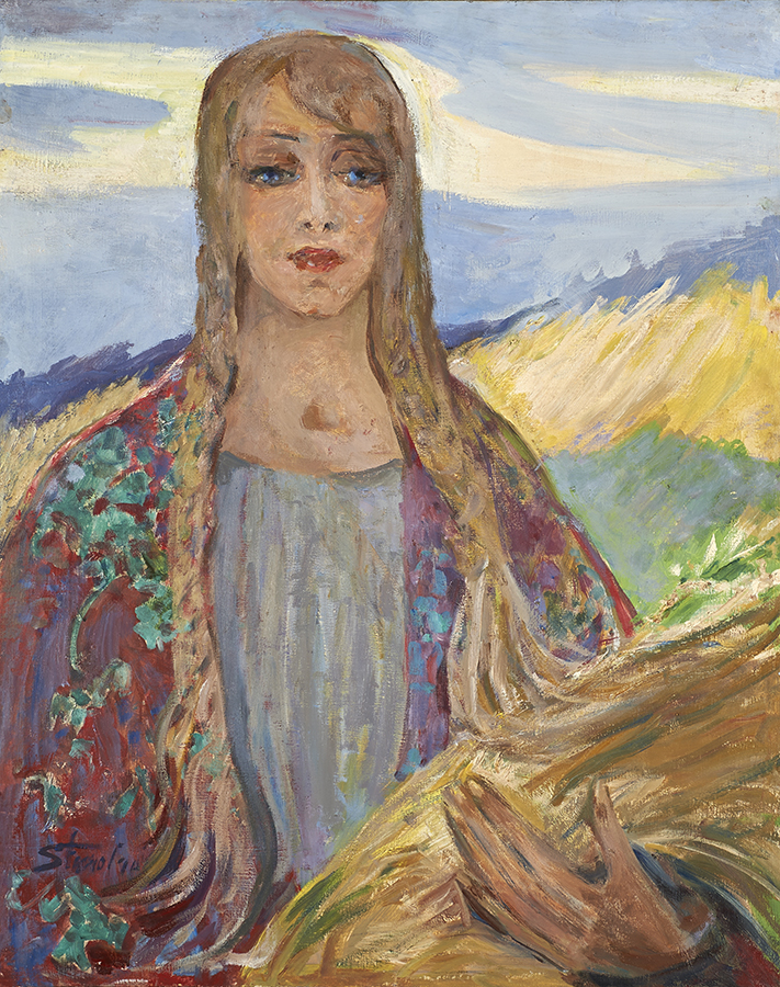 Stanisława Paradowska-Gajewska, W Polsce, ok. 1965; olej, płótno, 101 x 80 cm; nr inw. MPK/SW/103 Fotografia obrazu autorstwa Stanisławy Paradowskiej-Gajewskiej, zatytułowanego W Polsce, namalowanego farbami olejnymi na płótnie około 1965 roku. Przedstawia dziewczynę w ujęciu w półpostaci, na wprost. Ma długie jasne włosy splecione w dwa warkocze opadające na piersi, jeden kosmyk przez środek czoła sięga lewej brwi. Ma podłużną twarz, o różowawej karnacji, duże niebieskie oczy, prosty nos i pełne czerwone usta. Ubrana jest w szaroniebiską bluzkę z płytkim dekoltem, na ramionach ma wzorzystą, czerwono-zieloną chustę. Lewą ręką podtrzymuje snop zboża, z którym łączą się włosy lewego warkocza. W tle widzimy falujące, żółto-zielone łany i szaroniebieskie niebo z ciemnymi pasmami chmur.