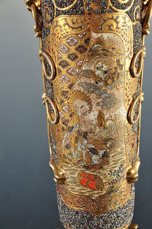 Dekoracja korpusu lampy, scena z japońskiej legendy o miłości Orihime i Hikoboshi; nr inw. MPK/CS/2050 ceramicznym korpusie lampy naftowej bogato dekorowana złoceniami przestrzeń. W polu scena ukazująca klęczącego mężczyznę trzymającego złoty przedmiot w dłoni, nad nim z chmur wyłania się pochylona w jego kierunku w popiersiu postać kobieca.