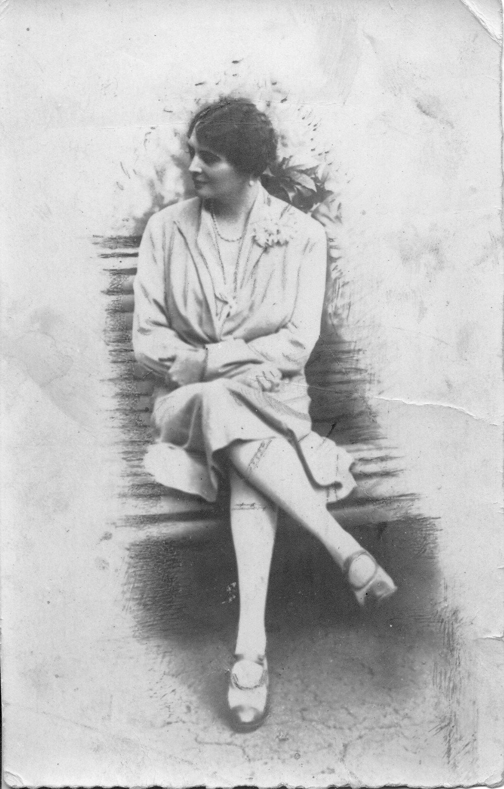 4. Maria z Potockich Adamowa Zamoyska, Kozłówka, lata 20. XX w. Fotografia archiwalna, czarno-biała, wykonana w latach dwudziestych XX wieku przedstawia Marię Adamową Zamoyską. Kobieta siedzi na ławce, w swobodnej pozie, z głową skierowaną w prawo. Ubrana jest w jasną sukienkę, ozdobioną z lewej strony, przy kołnierzu, kwiatem. Na szyi ma sznur pereł, a w uszach perłowe kolczyki.