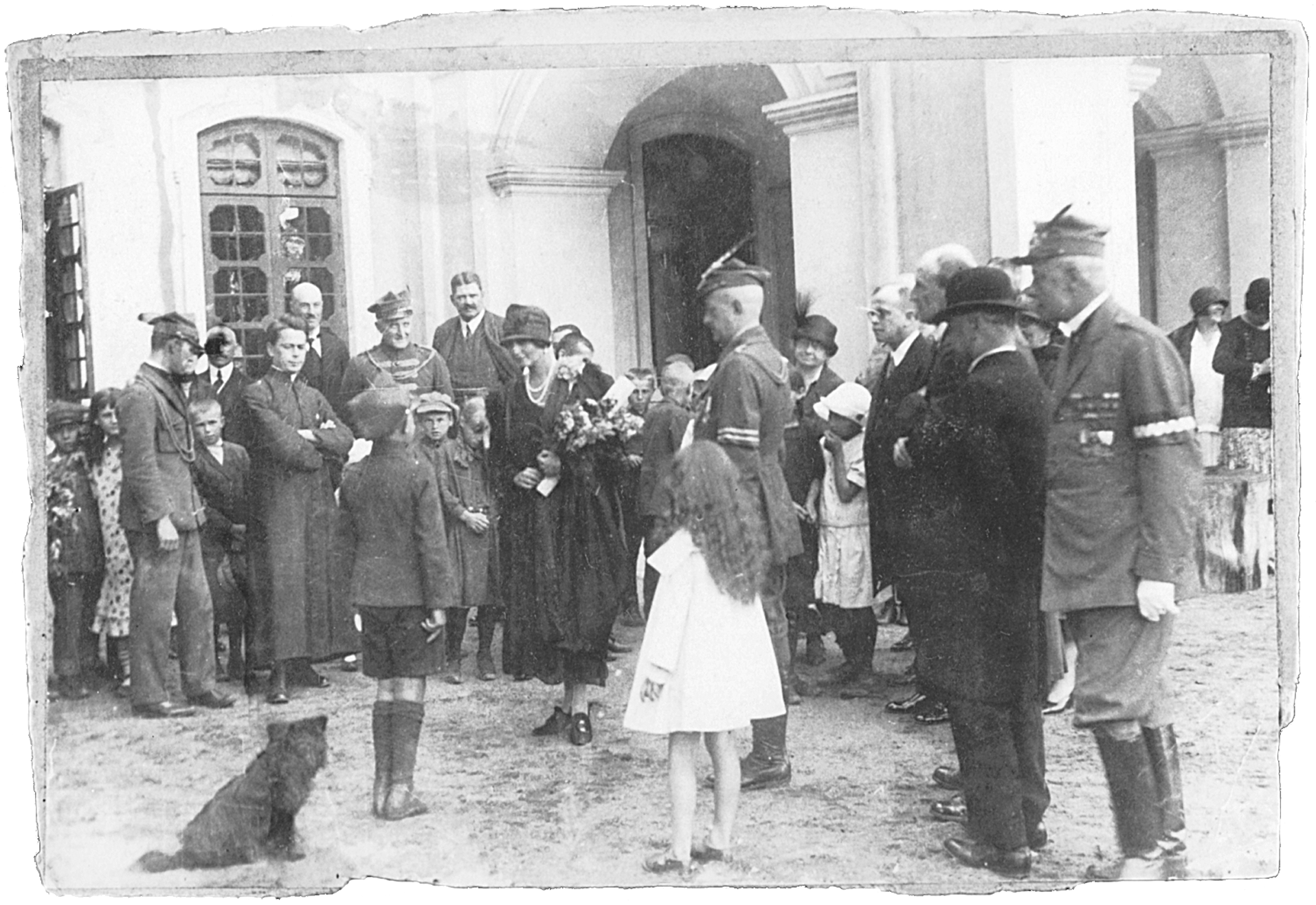 6. Imieniny „Matki Gniazda” – Marii Adamowej Zamoyskiej, Kozłówka, 1927 r. Fotografia archiwalna, czarno-biała, wykonana 2 sierpnia 1927 roku w Kozłówce, przedstawia moment wręczenia kwiatów i składania życzeń Marii Zamoyskiej z okazji imienin. Na fotografii grupa osób w różnym wieku, którzy otaczają kobietę z naręczem kwiatów i stojącego przed nią, w wyprostowanej pozie, chłopca. Niektórzy mężczyźni ubrani w mundury Towarzystwa Gimnastycznego „Sokół”.